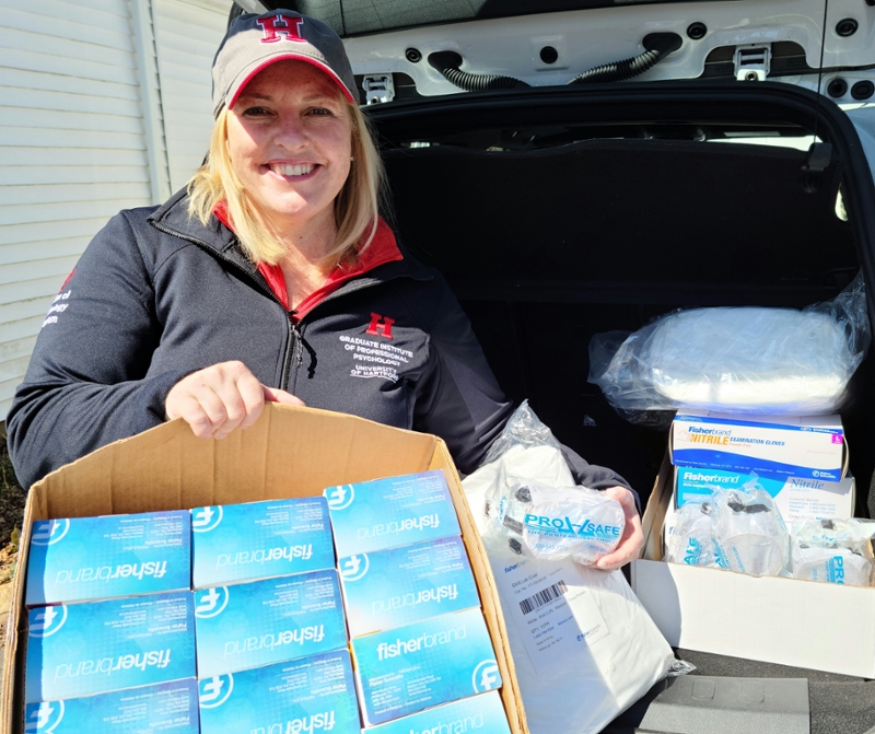 photo of Kelly weber in back of car with boxes of gloves, goggles, etc